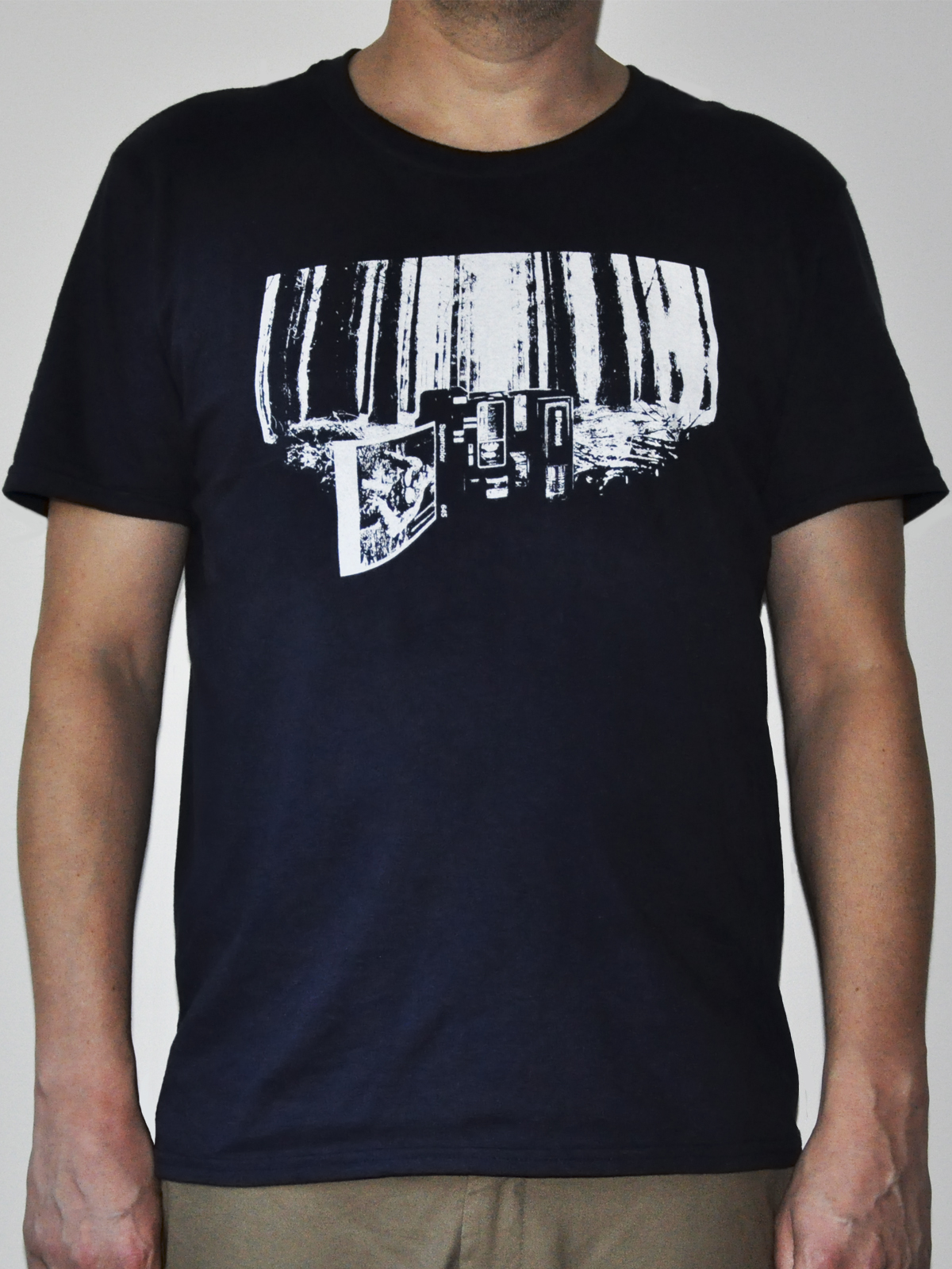 t-shirt depicting a polaroid camera on it's side in lonely woods presenting photo of angry yeti.